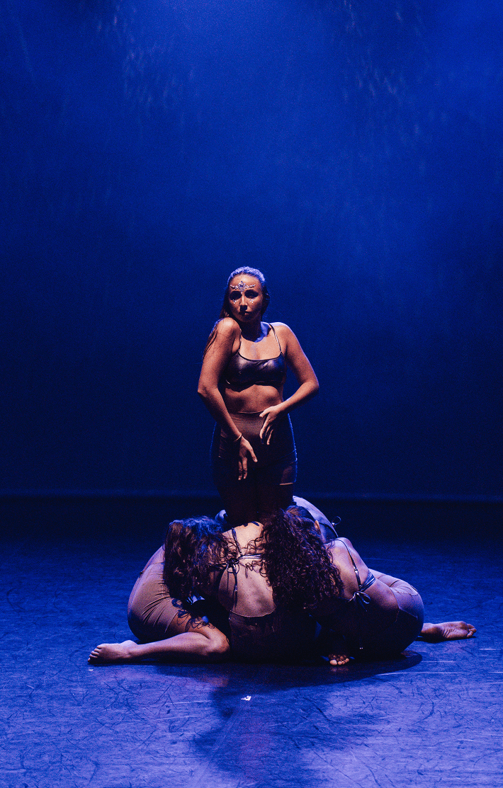 Danseuses en scène, éclairées par des lumières bleues.