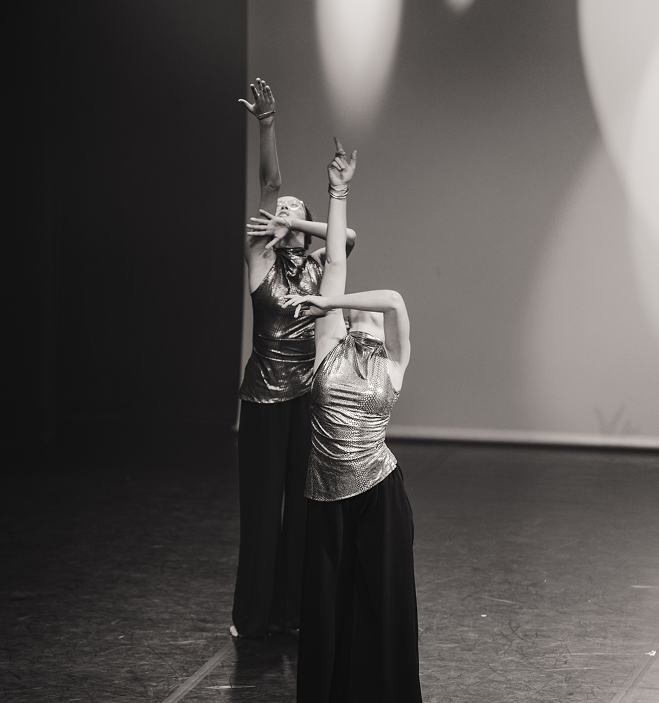 Deux danseuses en tenues métalliques exécutant une chorégraphie expressive sur scène.