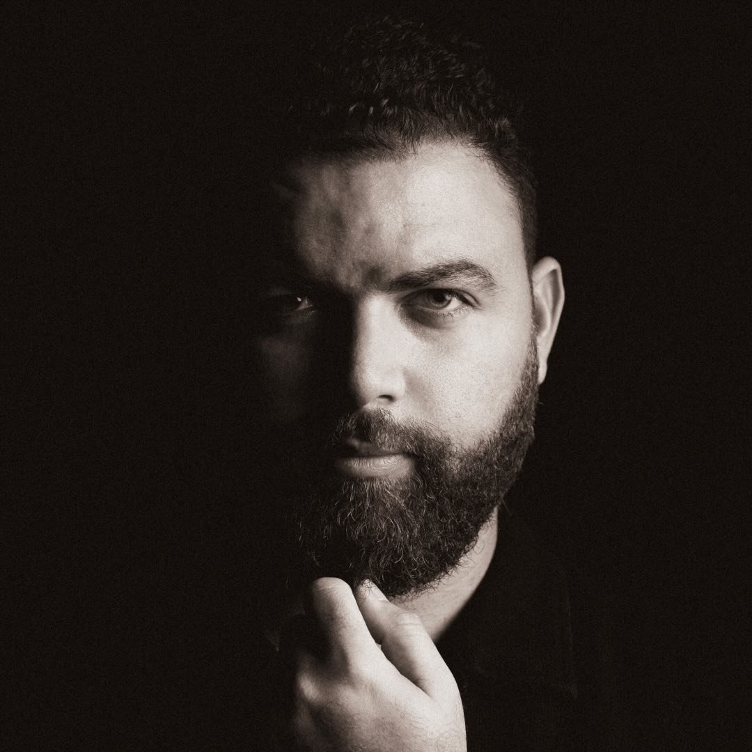 Portrait en noir et blanc d'un homme barbu pensif.
